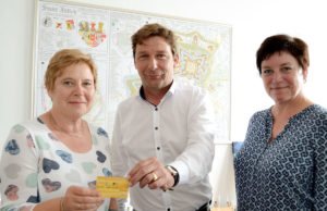 Bürgermeister Axel Fuchs (M) überreichte gemeinsam mit Anne Gatzen vom Amt für Stadtmarketing (r.) die 100. Ehrenamtskarte an Brigitte Barton-Wöllm (l.). Foto: Stadt Jülich/Stein